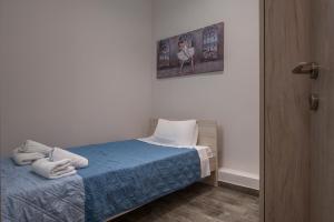 Un pequeño dormitorio con una cama con toallas. en Kosmos Service Apartment Absolute City Center 1-5 With Additional Cost Parking en Tesalónica