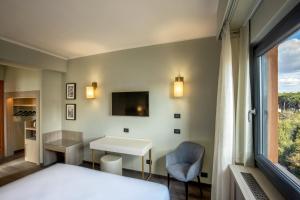 um quarto de hotel com uma cama, uma secretária e uma janela em Hotel Marc'Aurelio em Roma