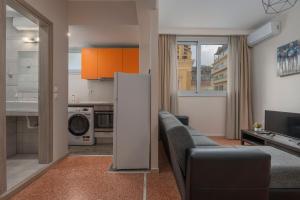 a living room with a couch and a kitchen at Kosmos Service Apartment Absolute City Center 1-5 With Additional Cost Parking in Thessaloniki