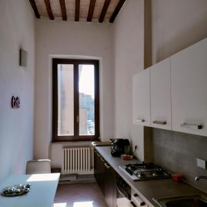 une cuisine avec un comptoir et une fenêtre dans l'établissement St Francis Apartaments, à Foligno