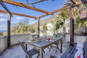 een tafel en stoelen op een patio met uitzicht op de oceaan bij Casa Pinzelli in Farinole