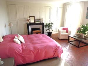 a bedroom with a pink bed and a fireplace at Clos Florésine B&B in Margny-lès-Compiègne