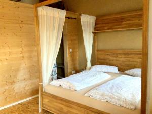 two beds in a room with wooden walls at Holstein-Höfle, Rindalphorn in Argenbühl