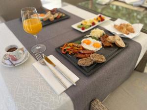 - une table avec une assiette de petit-déjeuner et un verre de jus d'orange dans l'établissement Center Luxury Rooms 2, à Split