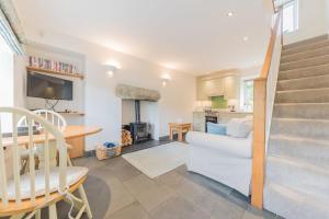 a living room with a white couch and a table at Fellside Cottage Coppermines Valley in Coniston