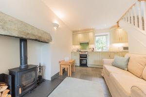 a living room with a couch and a wood stove at Fellside Cottage Coppermines Valley in Coniston