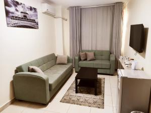 Una sala de estar con un sofá verde y una mesa. en Golden Plaza Hotel, en Amán