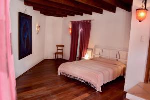 een slaapkamer met een bed en een stoel erin bij Stylish house in a real Finca with private garden in Uga