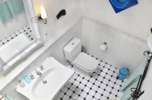 y baño con aseo blanco y lavamanos. en Stylish getaway with secluded Patio in lava Finca, en Uga