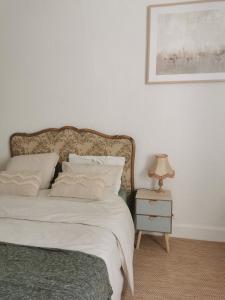 a bedroom with a bed and a table with a lamp at Au Petit Faubourg in Grignan