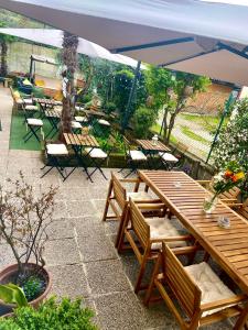 d'une terrasse avec des tables, des chaises et un parasol. dans l'établissement B&B Magnolia, à Vérone