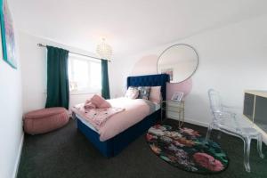 a bedroom with a bed with a mirror and a stool at Lancashire Living! in Preesall