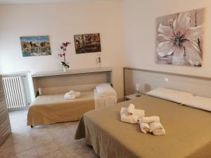 a bedroom with two beds with towels on them at Cabà Holiday Bardolino Gritti in Bardolino