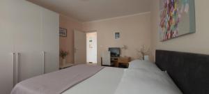 a bedroom with a white bed and a television at Apartment Mara in Dubrovnik