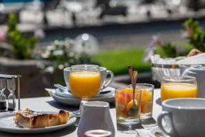un tavolo con piatti di cibo e bicchieri di succo d'arancia di Hotel Van Gogh a Saint-Rémy-de-Provence