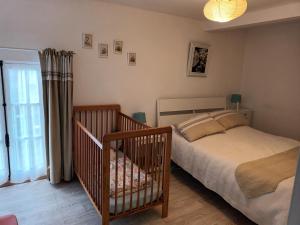 Sept-ventsにあるecrin de fleurs et verdureのベッドルーム(ベッド1台、ベビーベッド1台付)