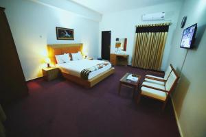 a hotel room with a bed and a chair at Hotel Red Line in Islamabad