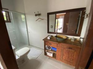 a bathroom with a sink and a toilet and a mirror at Casa Boutique in Cunha