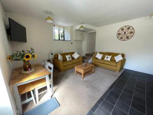 a living room with two couches and a table at The Hive in South Molton