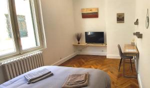 a bedroom with a bed and a tv and a desk at Histoire de Loire : GABRIELLE in Saumur