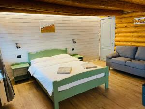 um quarto com uma cama verde e um sofá em Cabana din Groapa Frumoasa em Rasnov