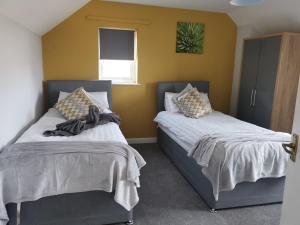 Een bed of bedden in een kamer bij SRK - Chalet House near Town with Large Garden by Srk Serviced Accommodation