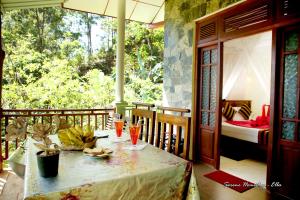 a room with a table and a bedroom with a bed at Serene Homestay Ella in Ella