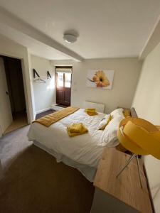 a bedroom with a large bed with yellow towels on it at The Hive in South Molton