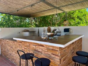 uma cozinha exterior com um balcão de tijolos e cadeiras em Casita Azahar Andalucia em Alhaurín de la Torre