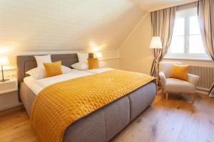 a bedroom with a large bed and a chair at Donauhof - Hotel garni in Weissenkirchen in der Wachau