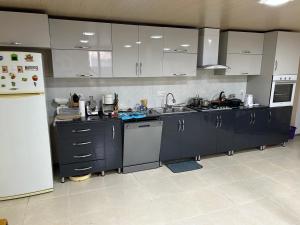 a kitchen with blue cabinets and a white refrigerator at Guest house Medea in Kutaisi