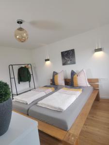 a bedroom with a large bed with pillows at Moderne Ferienwohnung Gartenblick in Amtzell
