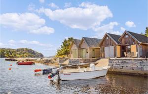 a boat is docked in the water next to houses at Gorgeous Home In Fitjar With Kitchen in Fitjar
