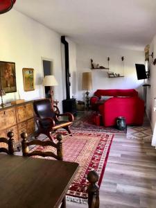a living room with a red couch and a table at Amazing 4-Bed Cottage lost in Montseny Nature in Arbúcies