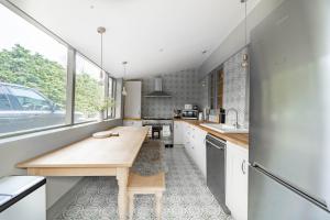 a kitchen with white cabinets and a wooden counter top at Suitable For Contractors 2 Double Beds and Sofa Bed Private Parking in Harlow +4 photos