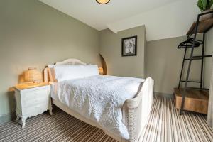 a bedroom with a white bed and a night stand at Suitable For Contractors 2 Double Beds and Sofa Bed Private Parking in Harlow