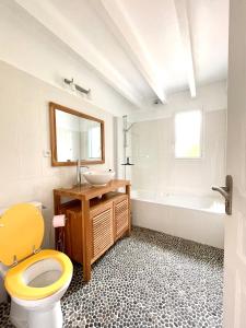 La salle de bains est pourvue de toilettes, d'un lavabo et d'une baignoire. dans l'établissement Maison familiale 11 couchages, proche de La Palue, à Crozon