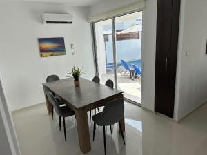 uma sala de jantar com uma mesa de madeira e cadeiras em Villa Mulberry Retreat 0,5Km From Everything em Coral Bay