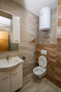 a bathroom with a toilet and a sink and a mirror at Markeeto apartments in Ilijaš