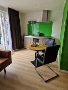 a living room with a table and a green wall at De Vier Seizoenen in Renesse