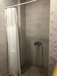 a shower with a white shower curtain in a bathroom at Cozy house in Gyumri