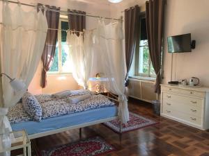 a bedroom with a canopy bed with curtains at Villa del Cigno in Lecco