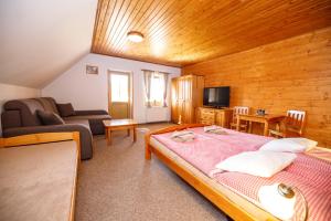 ein Schlafzimmer mit einem Bett und ein Wohnzimmer mit einem Sofa in der Unterkunft Penzion pod Šerákem in Ostružná