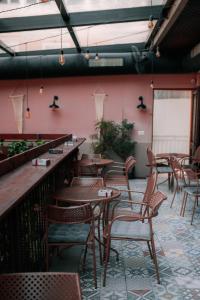 un ristorante con tavoli e sedie in legno e pareti rosa di Bed Station Hostel & Bar a Shkodër