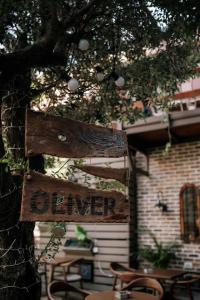 ein Schild, das von einem Baum vor einem Gebäude hängt in der Unterkunft Bed Station Hostel & Bar in Shkodra