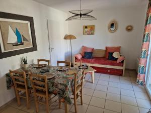 a dining room with a table and a couch at Chalet T3 Nature Piscine Tennis in Ondres