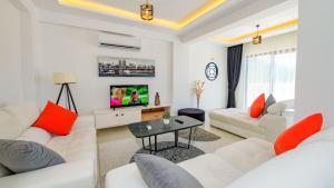 a living room with white furniture and a tv at Atlantis - 4 Bedroom Holiday Villa in Hisaronu in Oludeniz