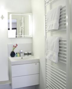 a white bathroom with a sink and a mirror at SCHLAFGUT! HOTEL-WILL.ICH Garni in Willich