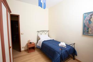 een slaapkamer met een bed met een blauwe deken bij CASA CANNEZIO in Ragusa