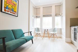 un soggiorno con divano e sedie verdi di Woodview Serviced Apartments by Concept Apartments a Londra